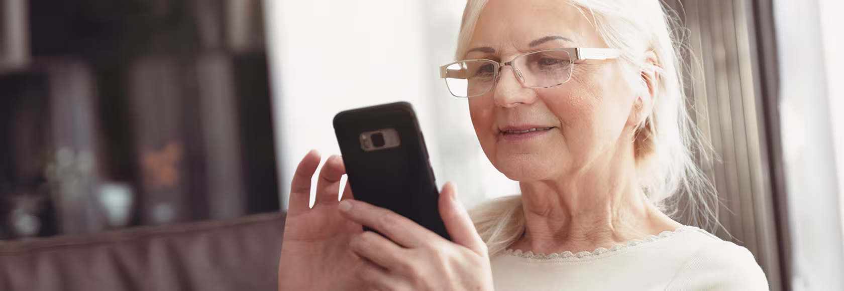 siwa pani z uśmiechem patrzy na telefon