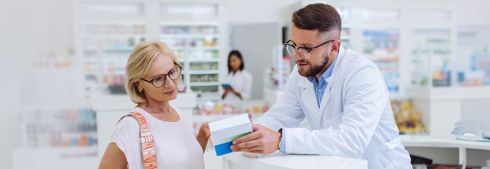 farmaceuta tlumaczy coś klientce, pani w srednim wieku w t-shircie
