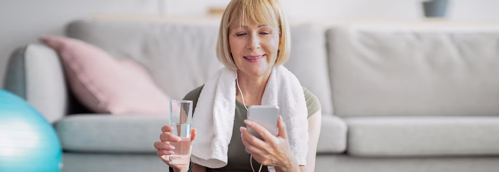Kobieta po ćwiczeniach patrzy na telefon