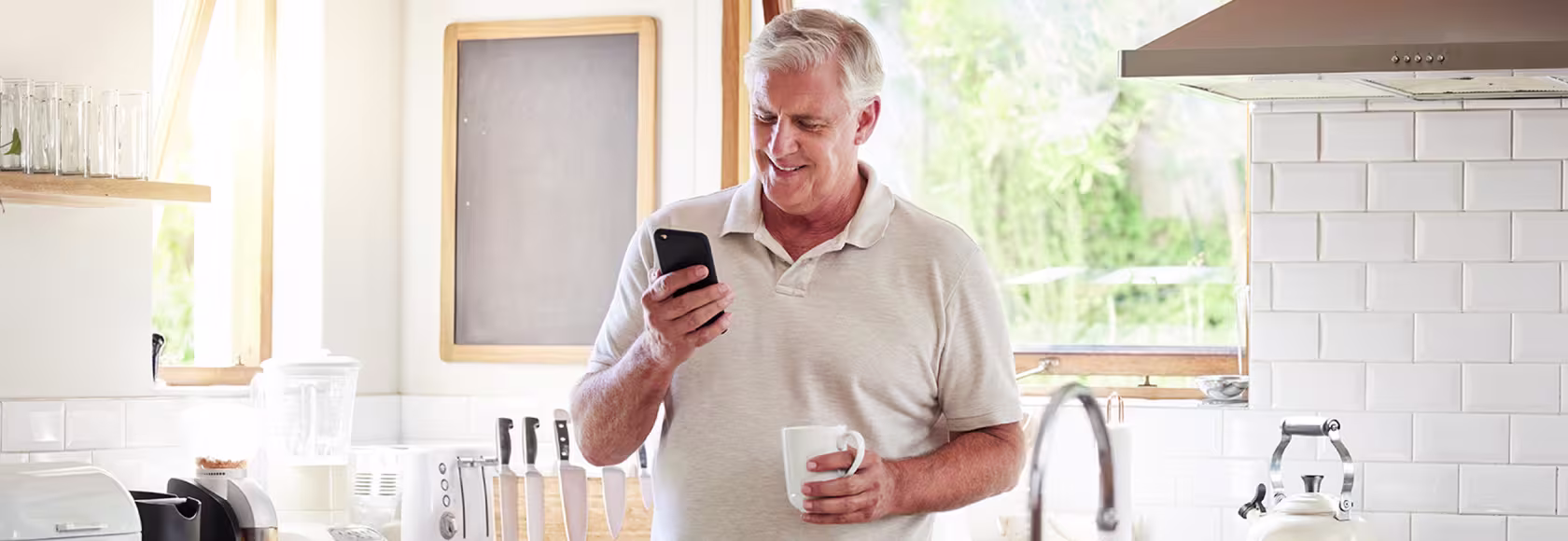 50latek w kuchni patrzy na telefon